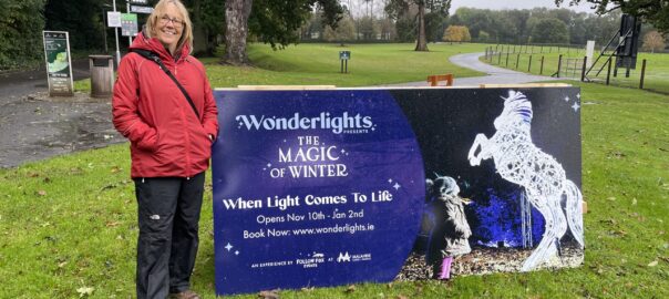 Val standing by the Wonderlights sign